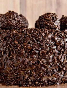 Brigadeirão de Chocolate cremoso decorado com granulado, servido em prato branco