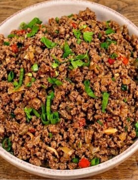 Panela com carne moída refogada bem soltinha e brilhante, salpicada com cheiro-verde fresco por cima.