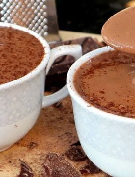Caneca de chocolate quente cremoso com canela polvilhada por cima