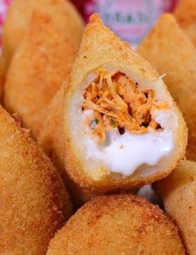 Coxinha dourada perfeita e crocante servida em um prato.