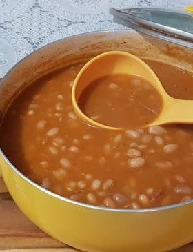 Feijão tradicional cozido servido com arroz e carne.