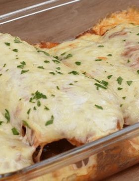 Frango à parmegiana servido com molho de tomate e queijo derretido.