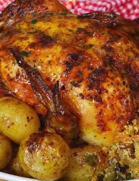 Frango assado recheado com farofa e batatas douradas.