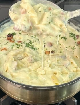 Macarrão ao creme de batata com bacon crocante e queijo derretido.