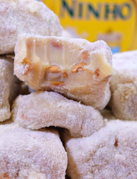 Pé de moça de leite Ninho cortado em quadradinhos e polvilhado com leite em pó