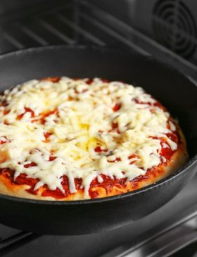 Pizza na frigideira com queijo derretido e rodelas de tomate
