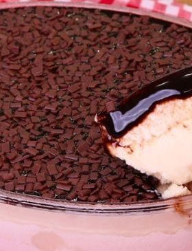 Sorvete com calda de chocolate na travessa decorada com confeitos