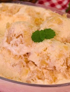 Sorvete de abacaxi com coco servido em uma taça.