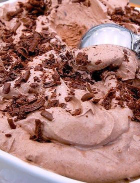 Sorvete de chocolate cremoso servido em taça com chocolate ao leite ralado por cima