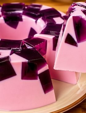 Pudim mousse de gelatina de 2 ingredientes desenformado em um prato, mostrando os cubinhos de gelatina envolvidos pelo creme mousse. Sobremesa de gelatina